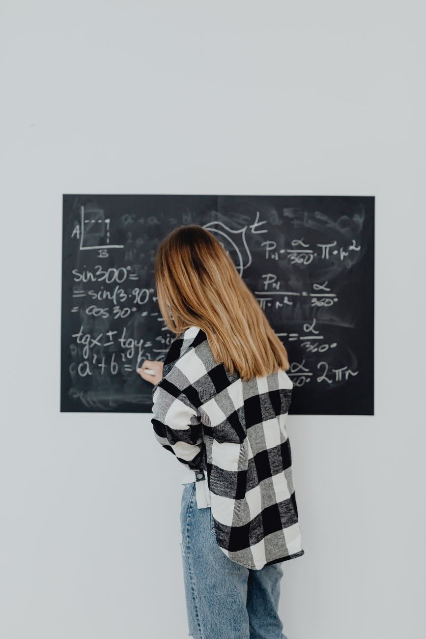 girl in plaid shirt solving a math problem